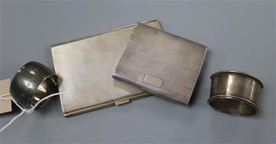 Two silver cigarette cases and two silver napkin rings.